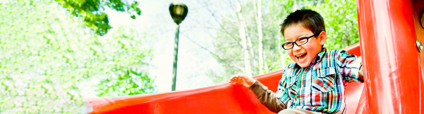 smiling boy on red slide